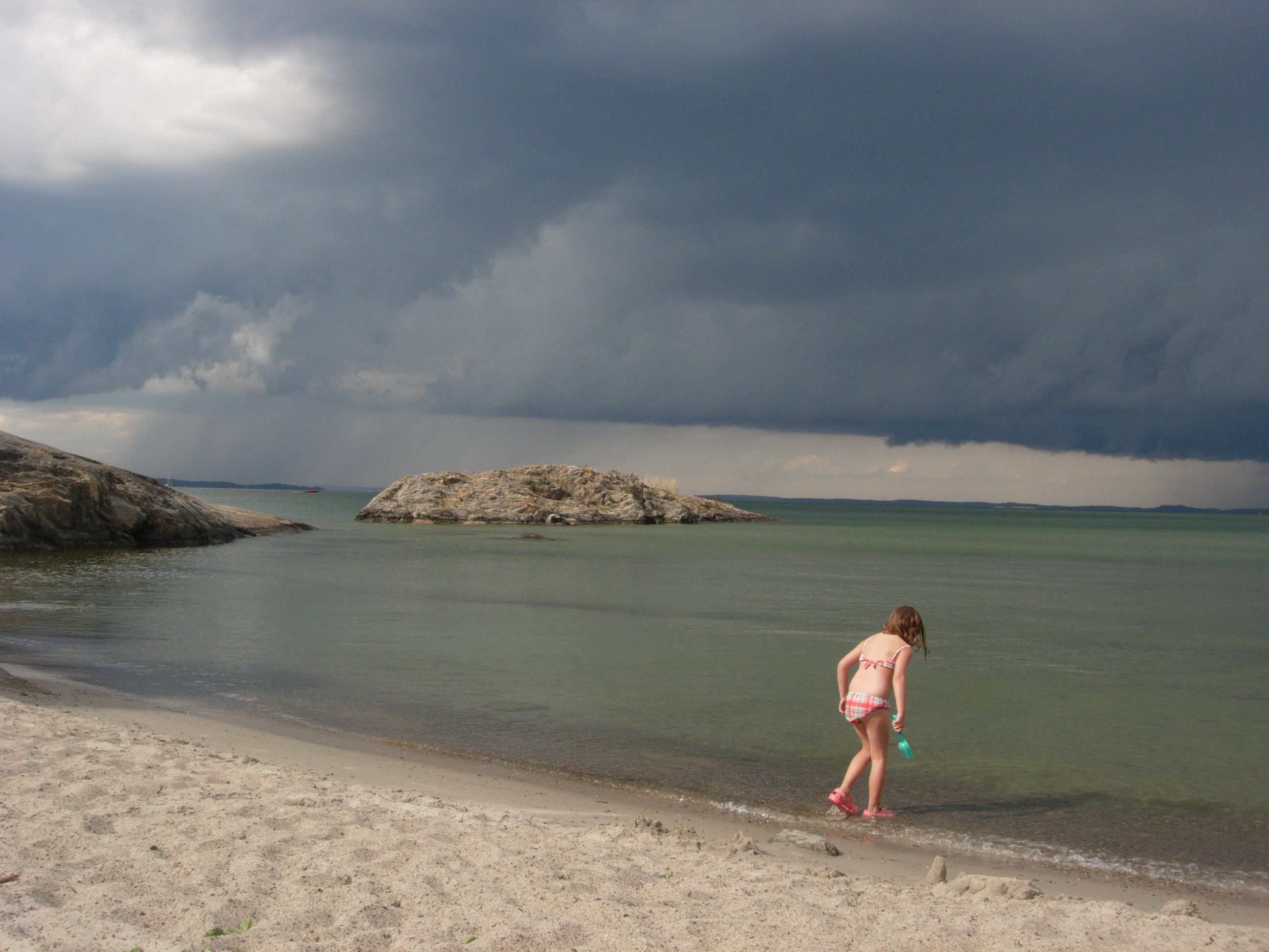 Sophie playing on the beach at Uto as a strom rolls in over the Baltic.